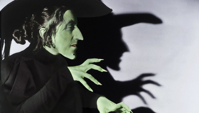 The Wicked Witch of the West casts a shadow of her profile and gasping hands on a wall
