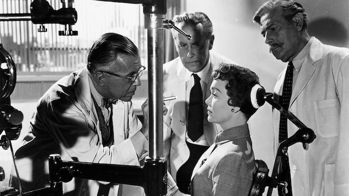 Jane Wyman, as Hellen Phillips in Magnificent Obsession, has her eyes examined by a team of doctors