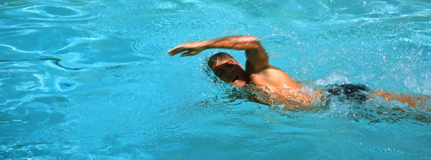 Burt Lancaster swims a lap in a swimming pool in THE SWIMMER
