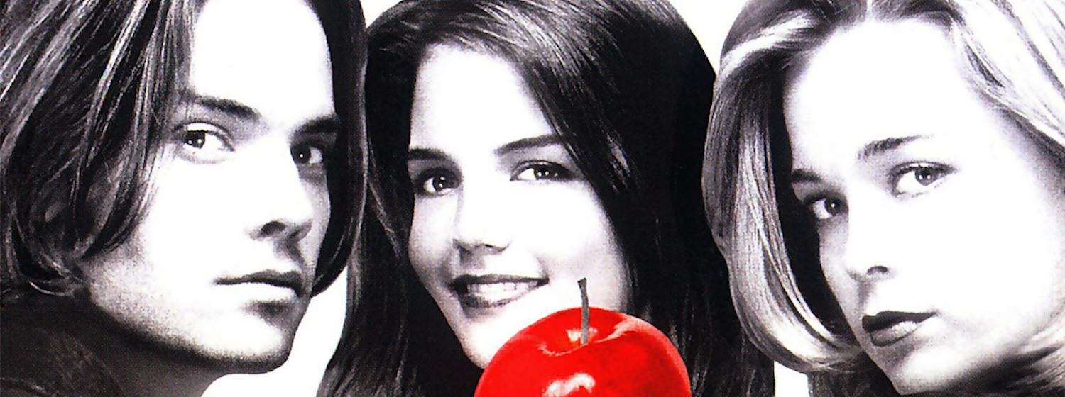 Black and white composite photo of Katie Holmes, Barry Watson and Marisa Coughlan. Holmes holds up a large bright red apple.