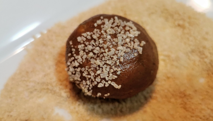 A ball of cookie dough covered in sugar