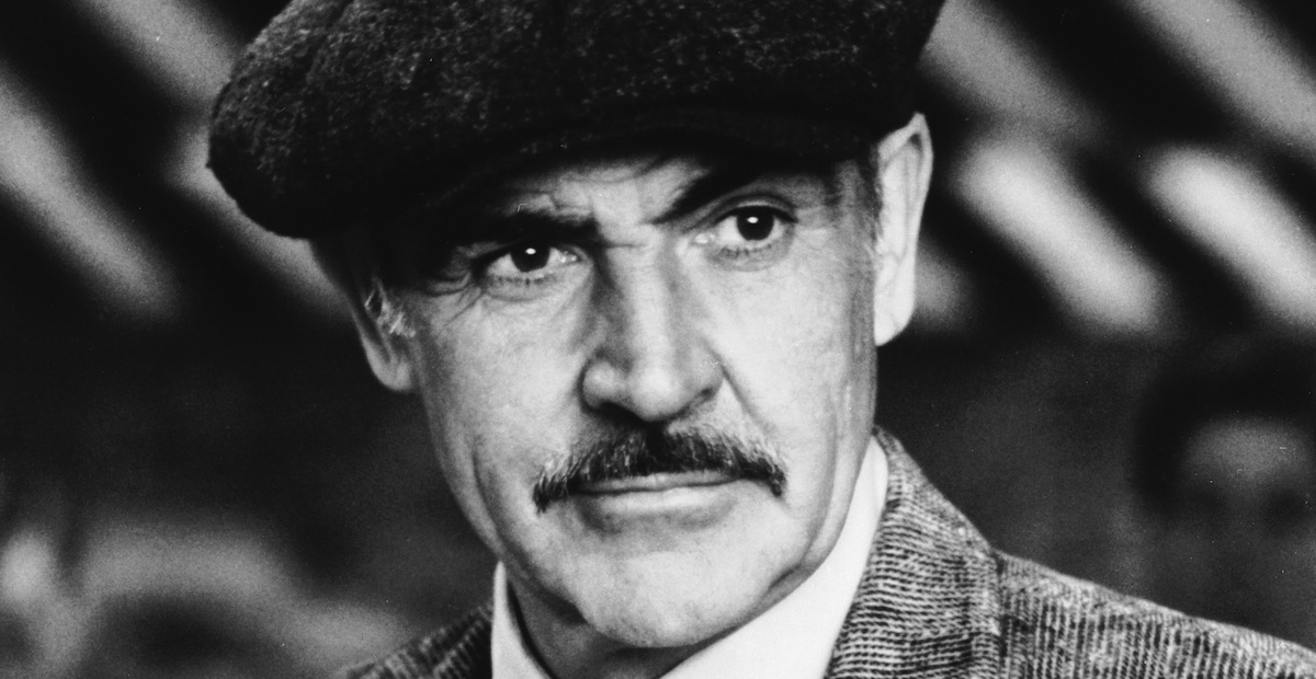 Close up of sean connery with a moustache and wearing a drivers cap in The Untouchables