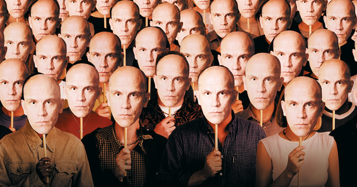 A crowd of people all hold masks of John Malkovich over their faces - detail from the poster for Being John Malkovich