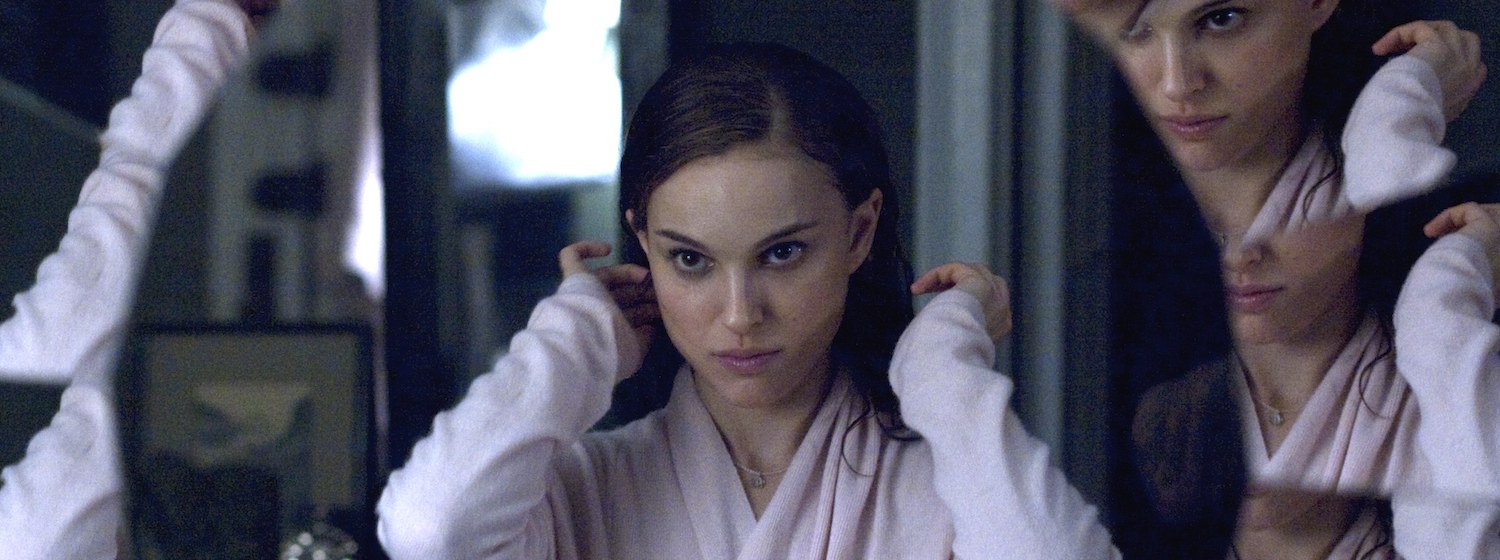 Natalie Portman does her hair as she looks into a many-faceted mirror in Black Swan