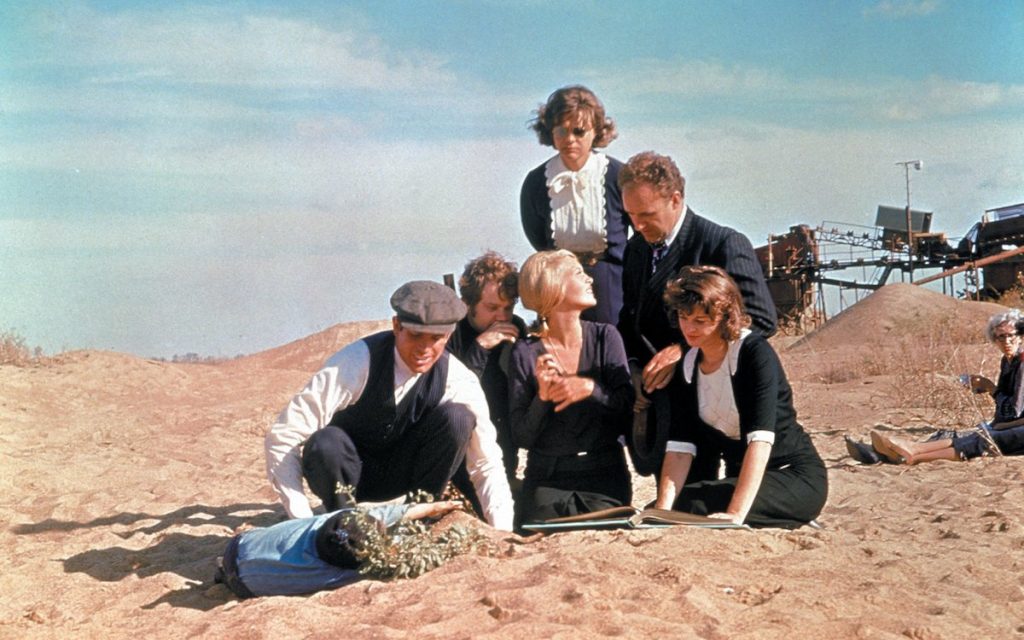 Bonnie and Clyde relax on the sand with their gang