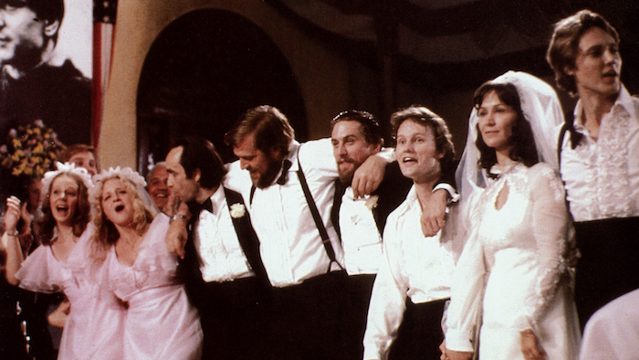The cast of The Deer Hunter lined up for a group photo in formal clothes during the wedding scene