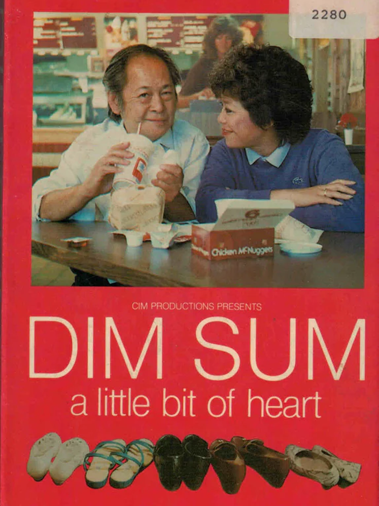 a middle aged Chinese man and woman sit side by side at a table in a mcdonalds with their meal in front of them. The woman smiles and looks at the man as the man lifts a cup to his mouth, smirking into the camera. From the poster for the film Dim Sum: A Touch of Heart (1985)