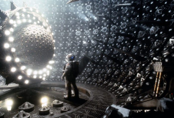 An astronaut stands in front of an ominous sphere in Event Horizon