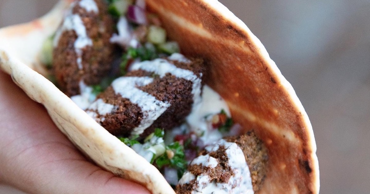 close up of a falafel sandwich on a pita