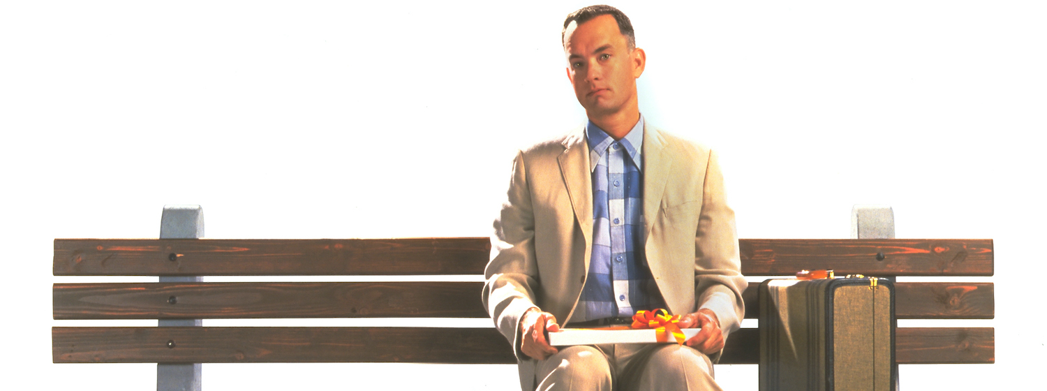 Tom Hanks as Forrest Gump sits on a bench
