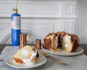 A slice of cake resembling a large Twinkie with a toasted marshmallow top