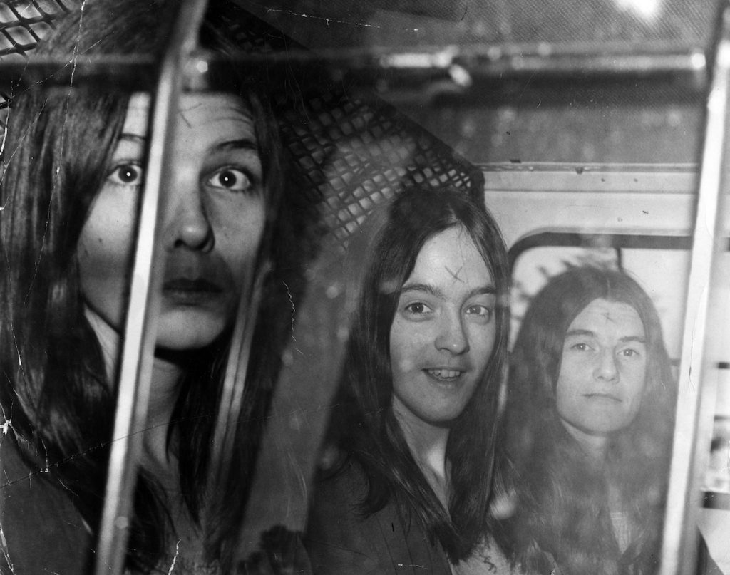 Followers of Charles Manson are transported in a police vehicle