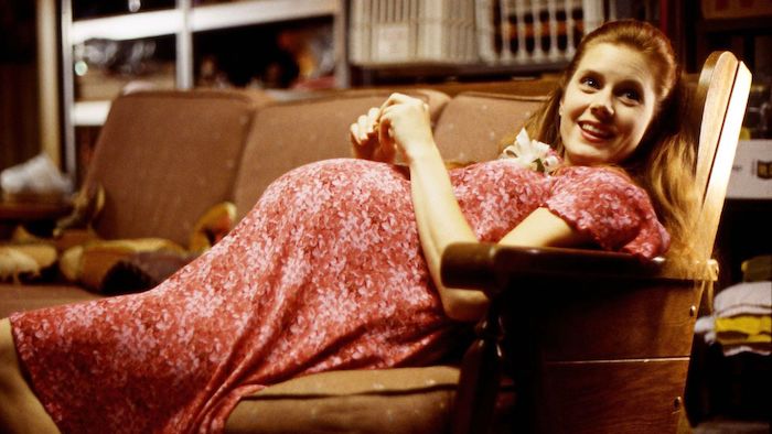 Amy Adams, pregnant, reclines on a sofa in Junebug