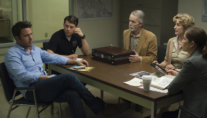 DF-11318_11319_COMP_R -- Nick (Ben Affleck, left) is questioned about the disappearance of his wife, Amy, by Detectives Boney (Kim Dickens, far right) and Gilpin (Patrick Fugit, in dark shirt), as Nick’s in-laws Marybeth and Rand Elliott (Lisa Barnes, David Clennon) look on.