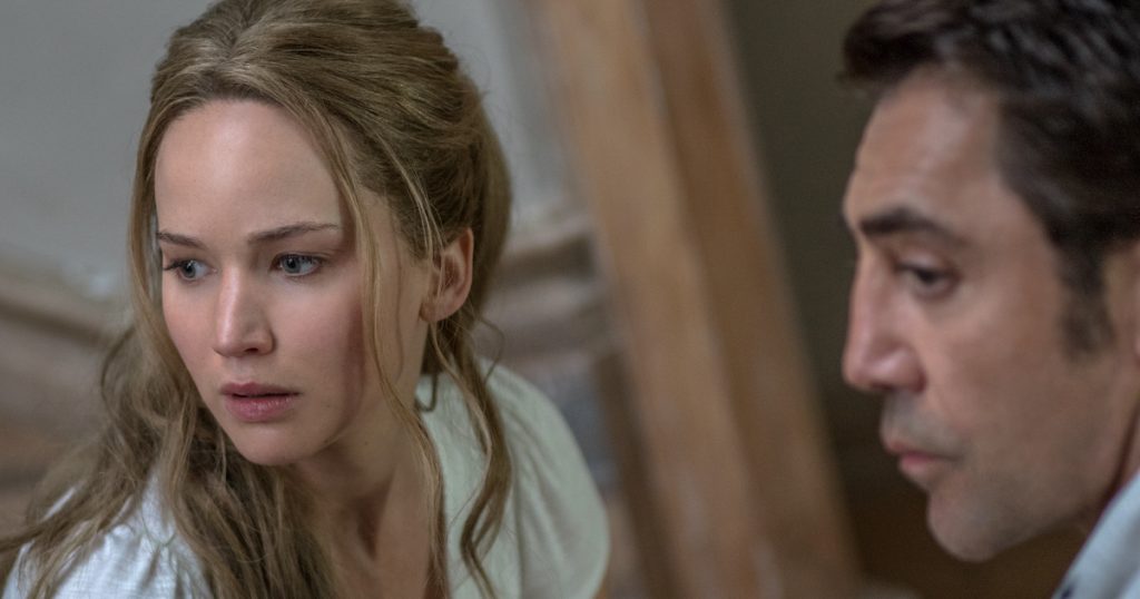 Jennifer Lawrence, looking startled, sits facing Javier Bardem