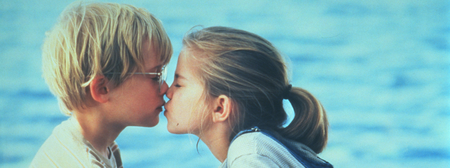 Vada (Anna Chlumsky) and Thomas J. (Macaulay Culkin) share their first kiss on a lakeside dock in My Girl (1991)