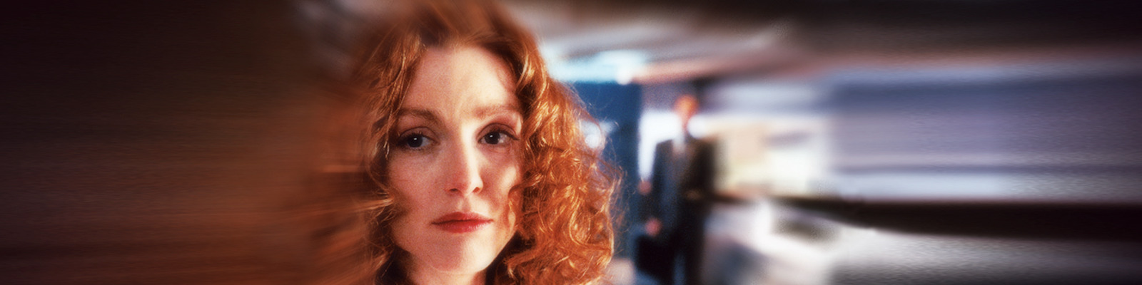 Promotional image for the film Safe shows a distorted close up of a worried Julianne Moore with the blurred figure of a man standing behind her