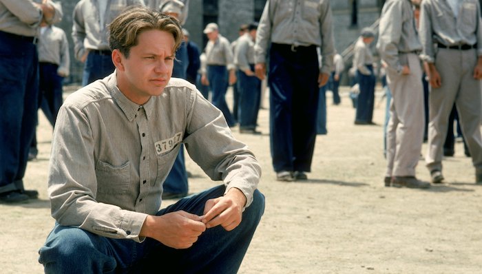 Andy (Tim Robbins)squats in the prison yard in The Shawshank Redemption