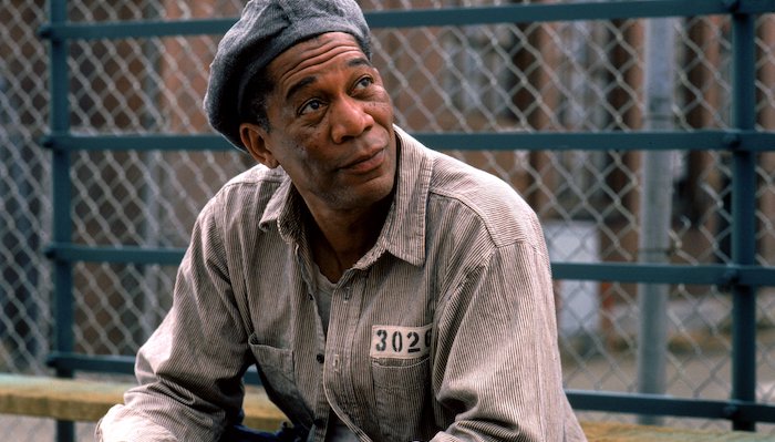 Ellis (Morgan Freeman)sits on bleachers in the prison yard in The Shawshank Redemption