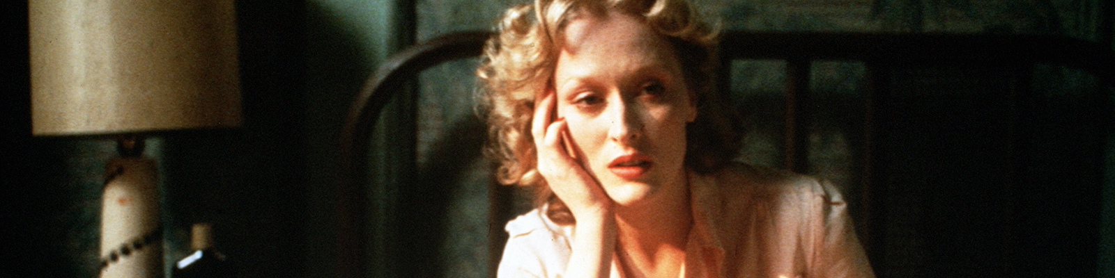 meryl streep sits in a bed with her face resting against her hand in sophie's choice