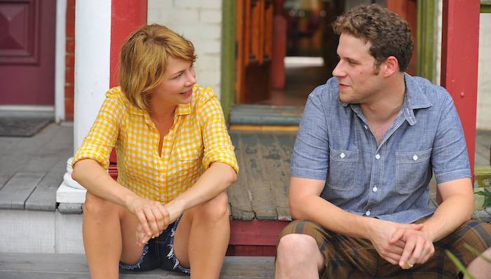 Michelle Williams and Seth Rogen sit on the front steps of a house in Take This Waltz