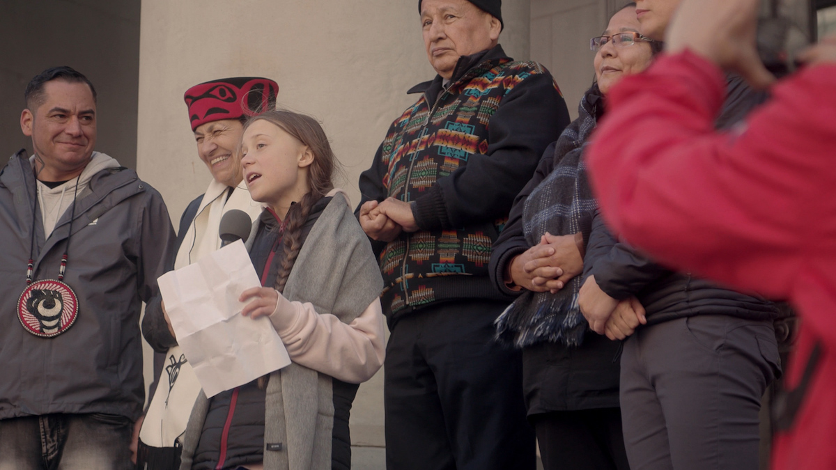 Climate activist Greta Thunberg stands with Indigenous leaders as she speaks to a climate protest