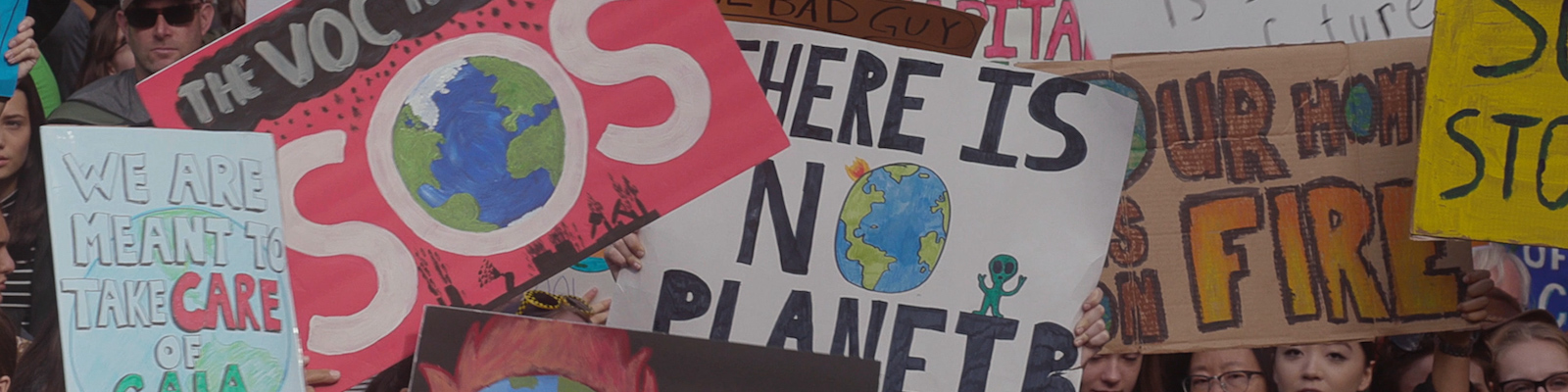 Young people hold signs at a climate change protest