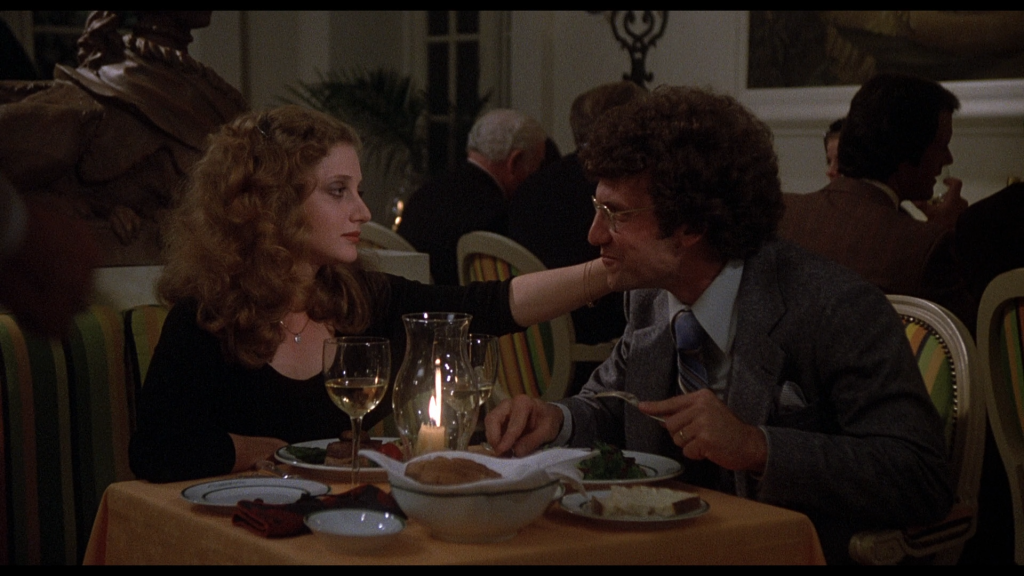 An adult Carol Kane has dinner in a restaurant with her husband